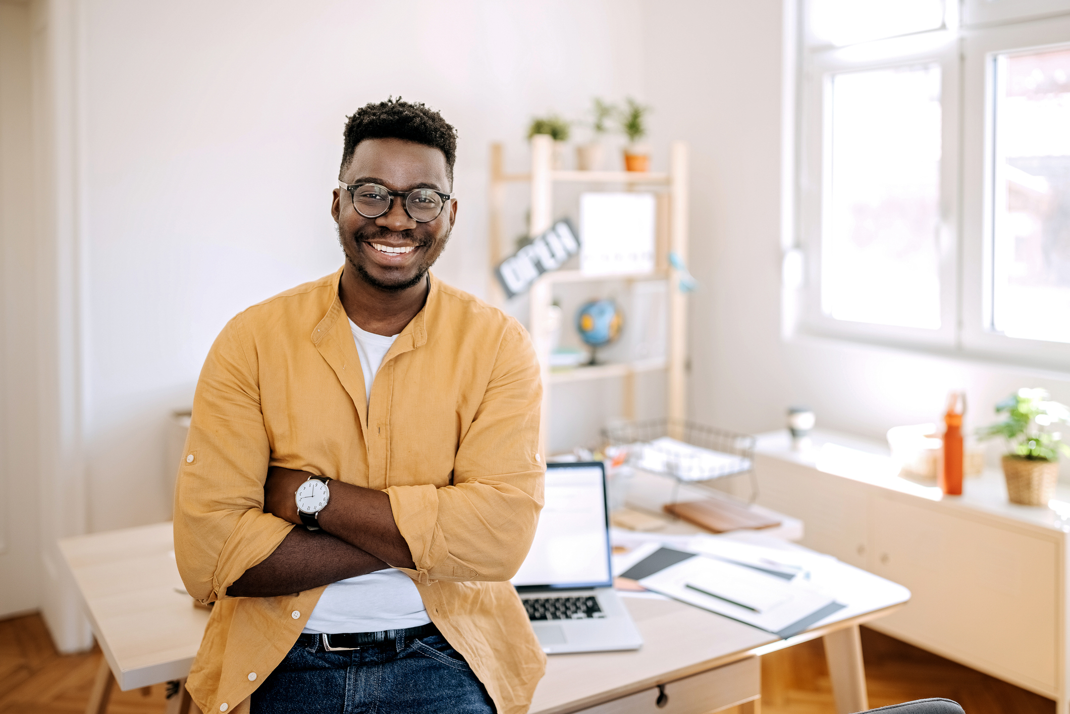 A man sitting on a desk smiling